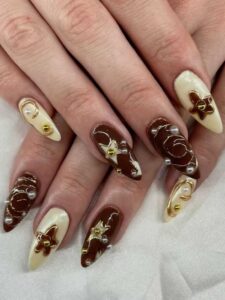 Brown-Chrome-Nails-with-Gold-Sculptures.